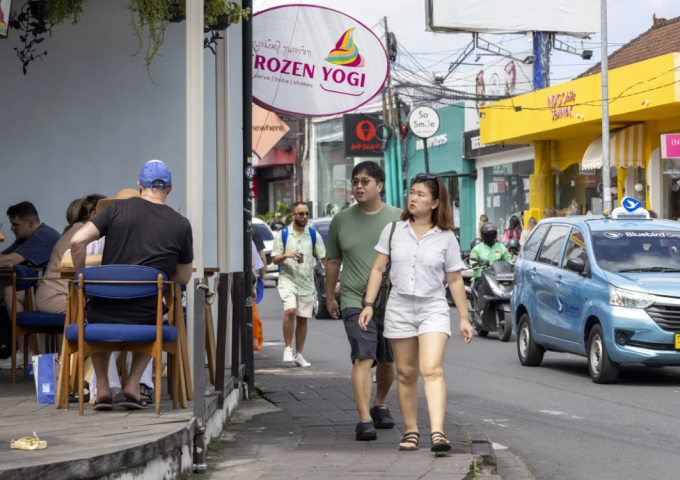 Khách quốc tế đi bộ trên đường phố Bali hồi đầu tháng 8. Ảnh: EPA