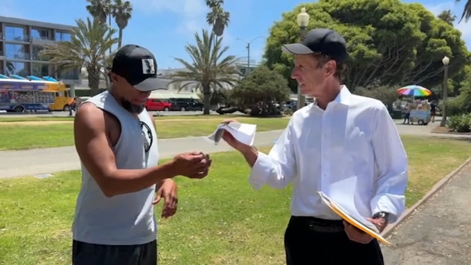 John Alle (phải) nói chuyện với một người vô gia cư ở Santa Monica, hạt Los Angeles, bang California hồi tháng 7. Ảnh: ABC7