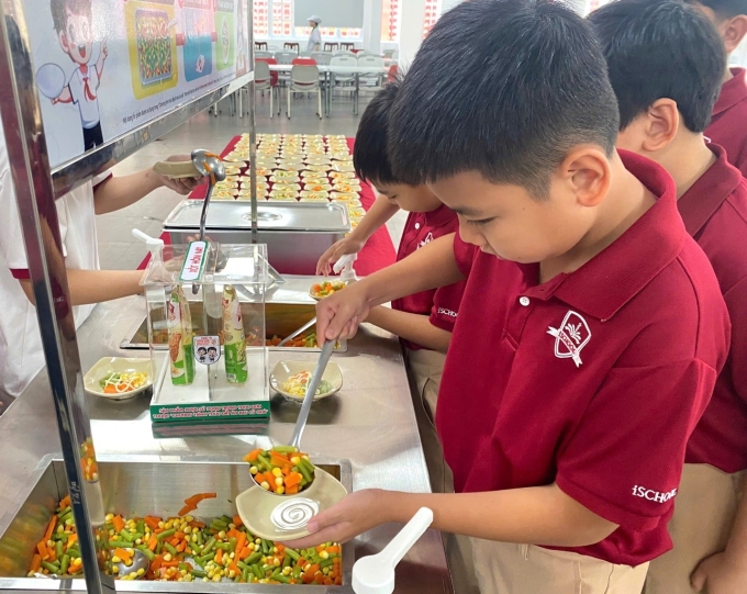 Các em học sinh (Khánh Hòa) xếp hàng tại quầy buffet rau trong giờ ăn trưa tại trường. Ảnh: Gia Hân