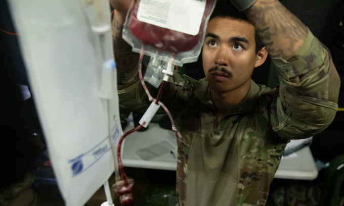 Lính quân y Mỹ bóp túi để đẩy nhanh quá trình truyền máu trong diễn tập ngày 12/9. Ảnh: US Army