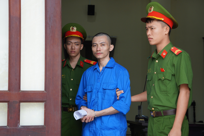 Cảnh sát dẫn giải bị cáo sau phiên xử. Ảnh: Nam An