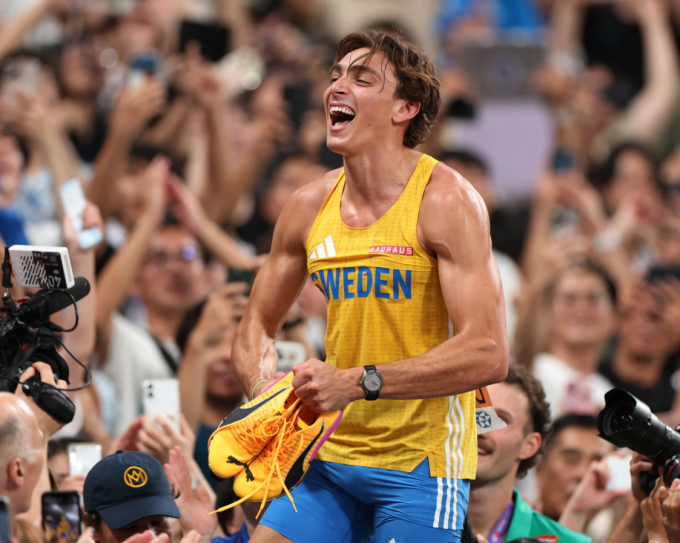 Armand Duplantis cầm đôi giày Claw ăn mừng sau khi lập kỷ lục. Ảnh: Reuters