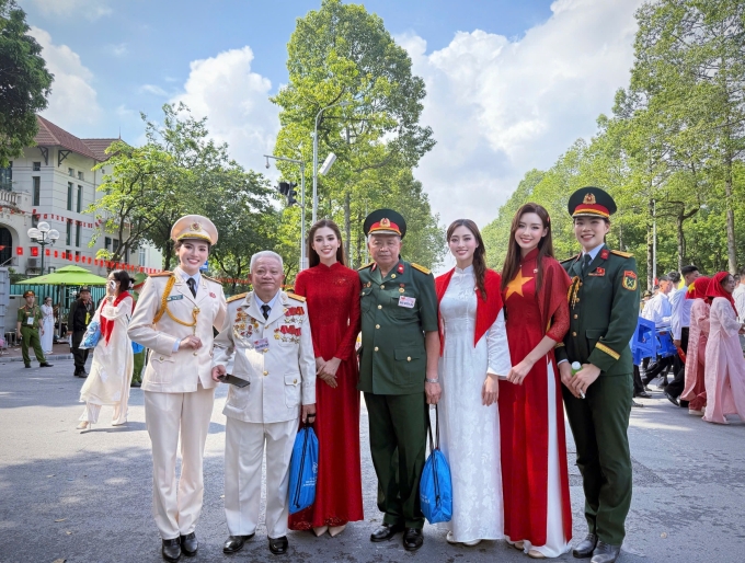 Hoa hậu Tiểu Vy, Lương Thùy Linh, Bảo Ngọc (diện áo dài từ trái sang) chụp ảnh cùng các chiến sĩ trên phố khi tham gia lễ diễu hành mừng 2/9. Ảnh: Nhân vật cung cấp