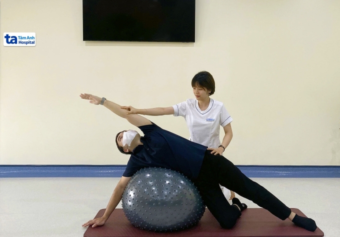 Chuyên viên vật lý trị liệu tập cho người cong vẹo cột sống. Ảnh: Bệnh viện Đa khoa Tâm Anh