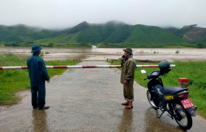 Cầu tràn Ba Lòng ngập 1 m được lực lượng chức năng rào chắn. Ảnh: Anh Ninh