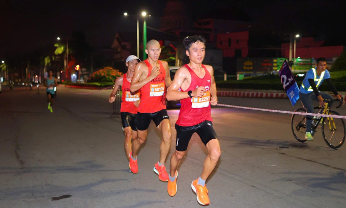 (Từ phải sang) Trương Trí Tâm, Triệu Tiến Luyện và Lý Nhân Tín ganh đua ở nhóm đầu 21km. Ảnh: VnExpress Marathon