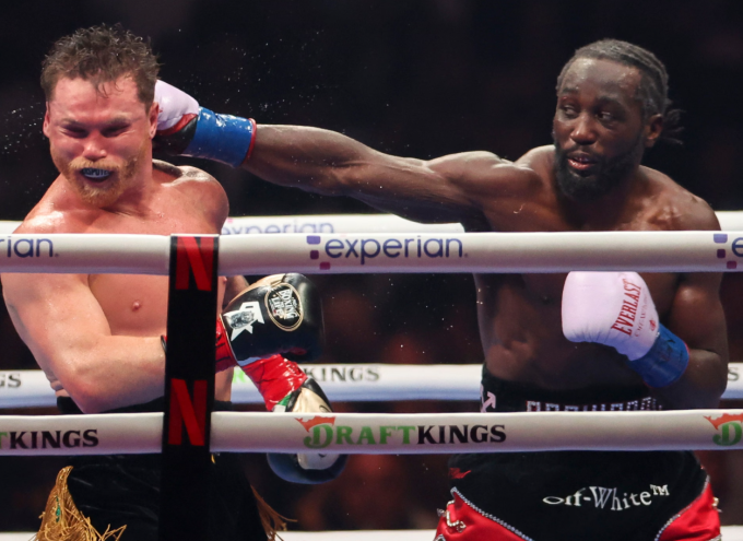 Terence Crawford (phải) tung đòn trúng mặt Canelo Alvarez trong trận thống nhất các đai hạng siêu trung trên sân Allegiant, Las Vegas, Mỹ ngày 13/9/2025. Ảnh: EPA