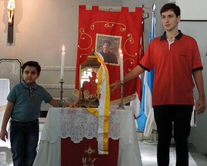 Matheus Vianna chạm vào thánh tích Carlo Acutis trong nhà thờ St. Sebastian ở Mato Grosso do Sul, Brazil, năm 2015. Ảnh: Nhà thờ St. Sebastian