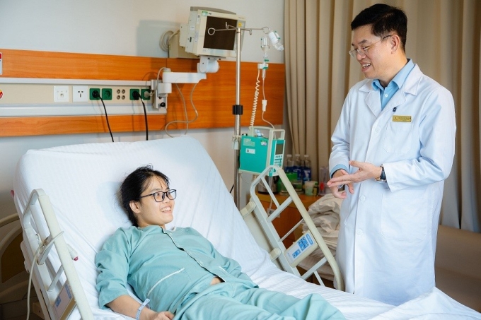 Bác sĩ Lê Văn Thành trò chuyện với bệnh nhân Dương Thị Mến sau ca ghép gan thành công. Ảnh: Vinmec