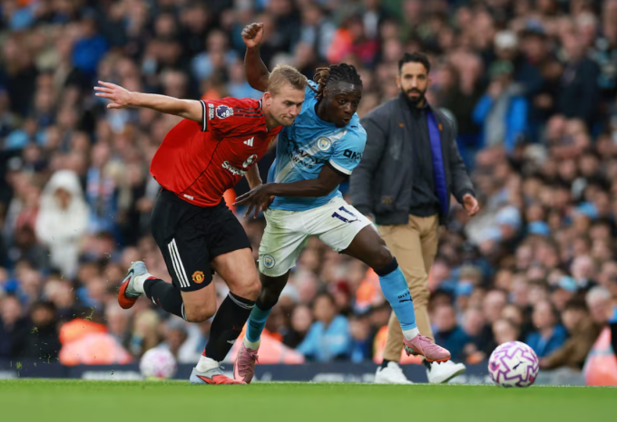Matthijs de Ligt (áo đỏ) tranh chấp với Jeremy Doku. Ảnh: Reuters