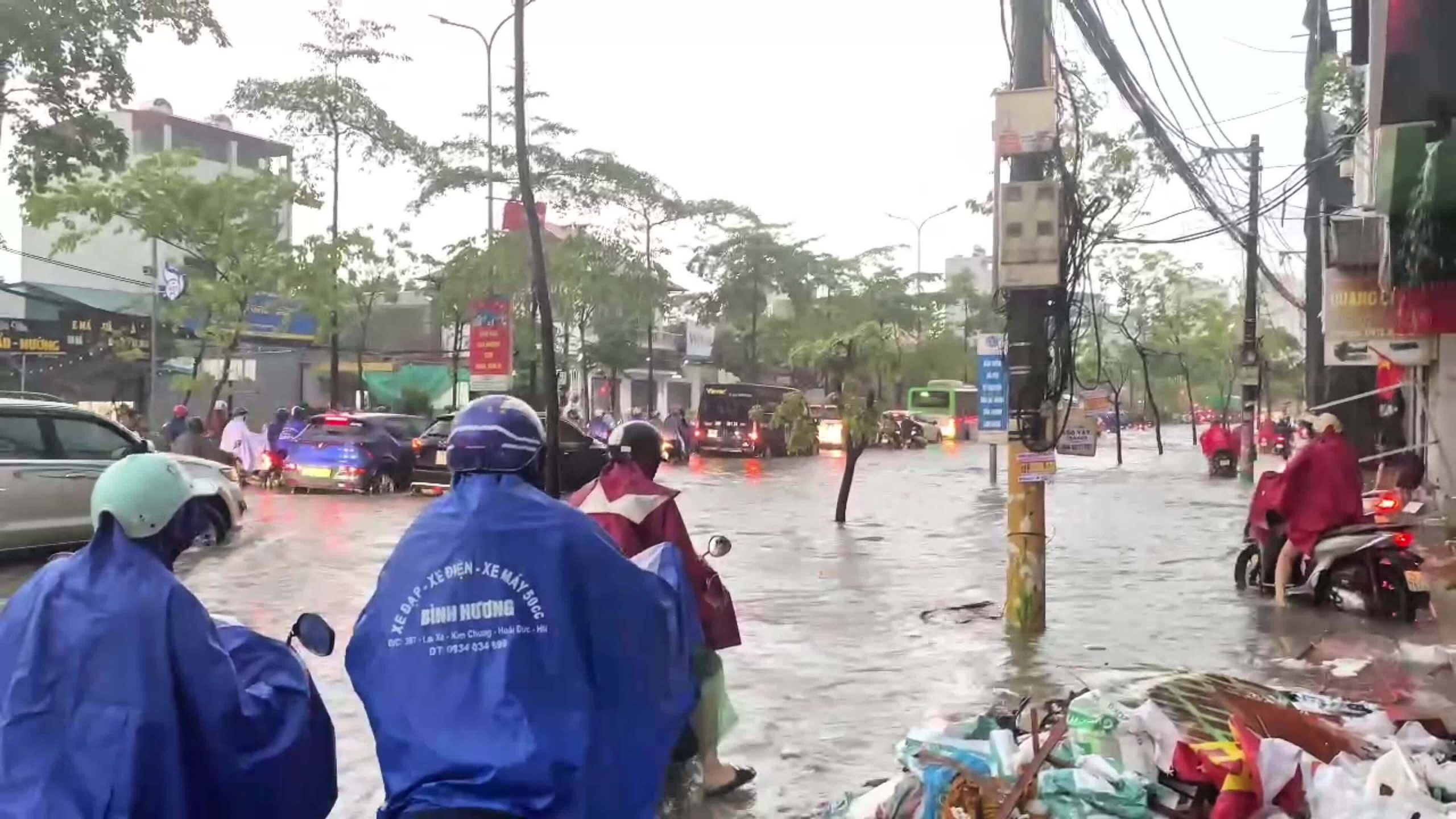 Người Hà Nội vật lộn đưa con đi học, đi làm trong mưa lớn