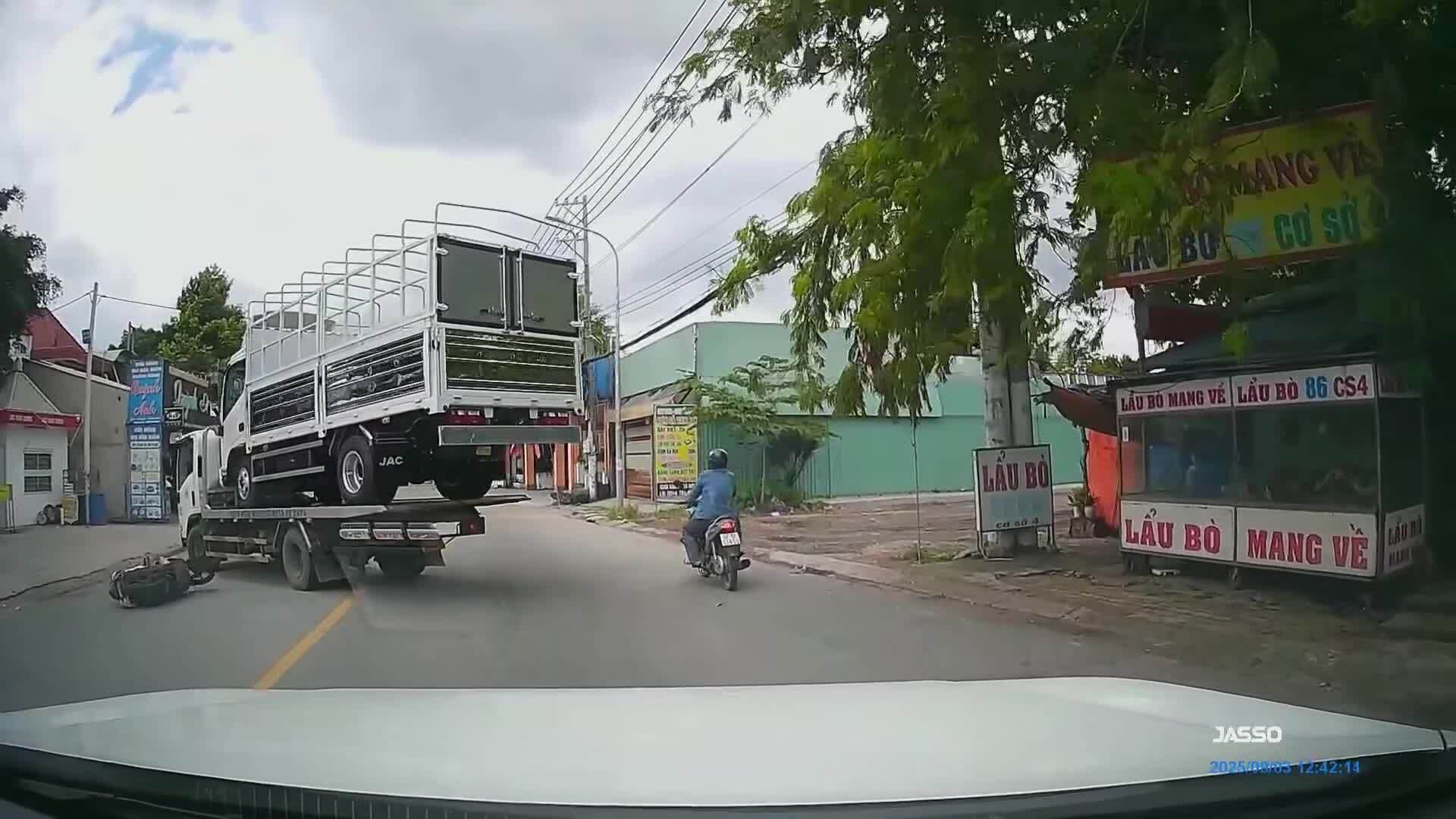 Ôtô chuyển làn đột ngột khiến người phụ nữ bất ngờ ngã xe máy