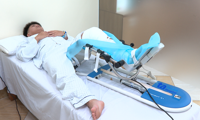 Anh Quí phục hồi chức năng bằng máy gập duỗi thụ động chi dưới. Ảnh: Bệnh viện Đa khoa Tâm Anh
