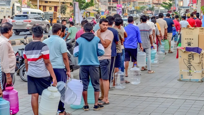 Người dân xếp hàng lấy nước uống tại Rajarajeshwarinagar, ngoại ô Bengaluru. Ảnh: Jithendra M/India Express