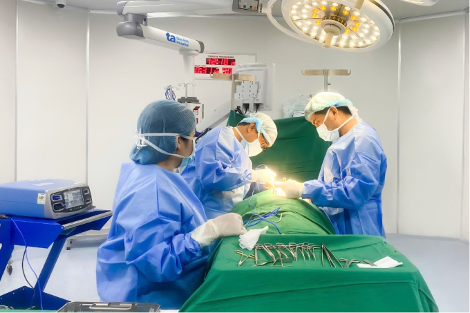 Bác sĩ Huân (giữa) đang phẫu thuật cho người bệnh. Ảnh: Bệnh viện Đa khoa Tâm Anh