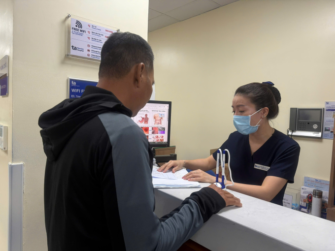 Anh Trí (trái) làm thủ tục xuất viện. Ảnh: Bệnh viện Đa khoa Tâm Anh