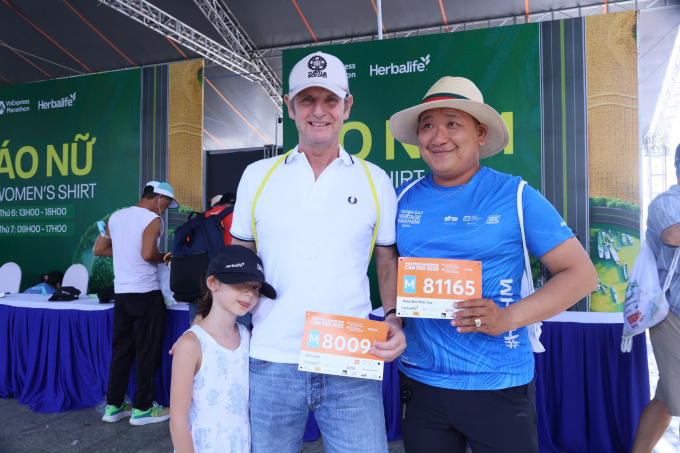 Richard cùng con gái vui vẻ check-in cùng một nam runner người Việt tại expo của giải. Ảnh: Hải Long