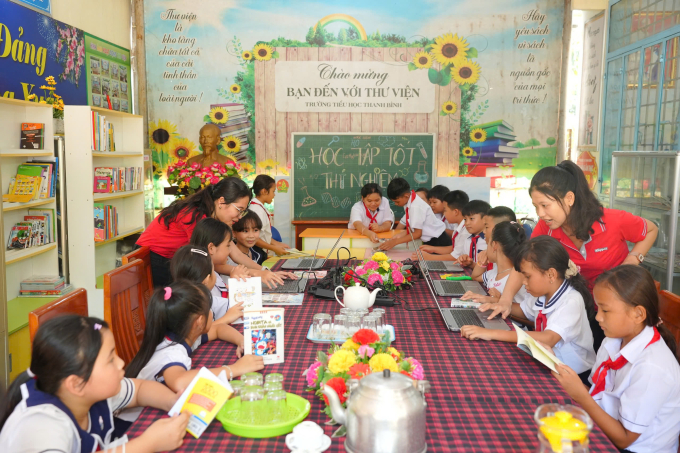 Các em học sinh trường Tiểu học Thanh Bình đọc sách do đơn vị trao tặng. Ảnh: Keppel