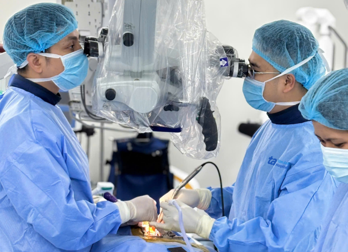 Bác sĩ Hà (trái) cùng êkíp phẫu thuật cho bệnh nhân bằng kính vi phẫu và máy C-arm. Ảnh: Bệnh viện Đa khoa Tâm Anh