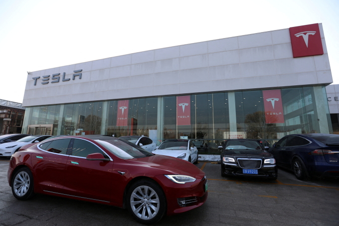 Xe Tesla đi qua một cửa hàng của hãng này tại Bắc Kinh (Trung Quốc) tháng 1/2024. Ảnh: Reuters