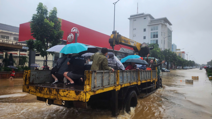 Chiếc xe tải chở khách và người dân vượt các điểm ngập tới điểm an toàn. Ảnh: Võ Thạnh