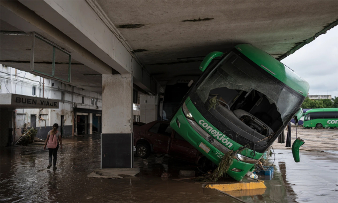 Xe buýt bị nước lũ cuốn vào nhà chờ tại Poza Rica, bang Veracruz, Mexico ngày 11/10. Ảnh: AP