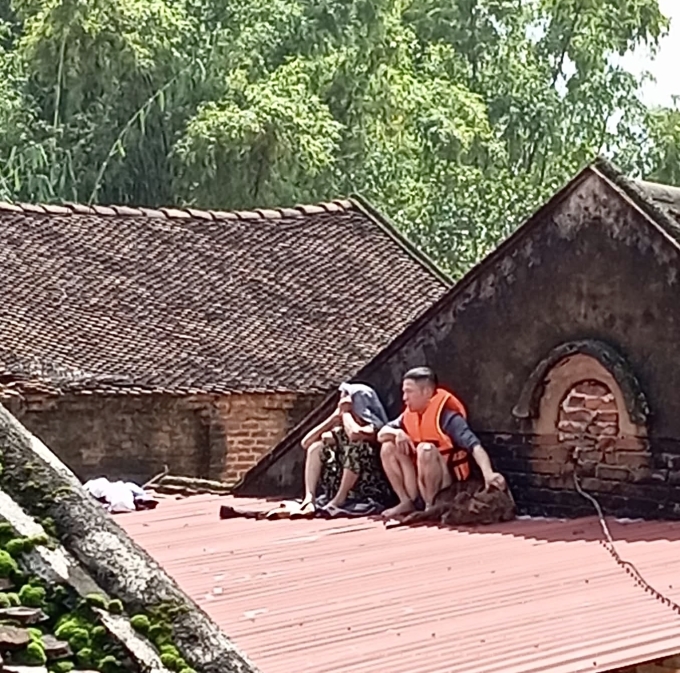 Hàng xóm cạnh nhà chị Lan Anh tại xóm Hạnh Phúc, xã Phú Bình cũng trèo lên mái nhà ngồi khu nước lũ dâng cao, sáng 8/10. Ảnh: Nhân vật cung cấp