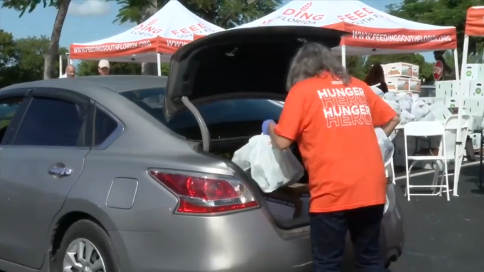 Tình nguyện viên Feeding South Florida chất thực phẩm hỗ trợ vào cốp xe của nhân viên liên bang, ngày 28/10. Ảnh: 7 News