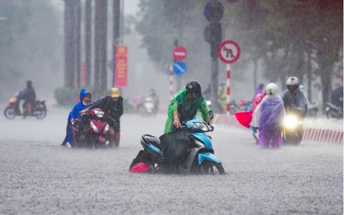 Trên phố Nguyễn Hoàng, nhiều phải dắt xe cuốc bộ dưới mưa to, nước dâng cao khoảng 0,4 m. Ảnh:Tùng Đinh