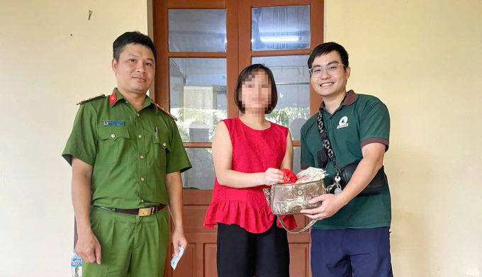 Anh Trung Kiên (đầu tiên từ phải sang) trao trả lại chiếc túi cho chị T (áo đỏ) tại công an phường Phan Đình Phùng, Thái Nguyên ngày 11/10. Ảnh: Công Minh