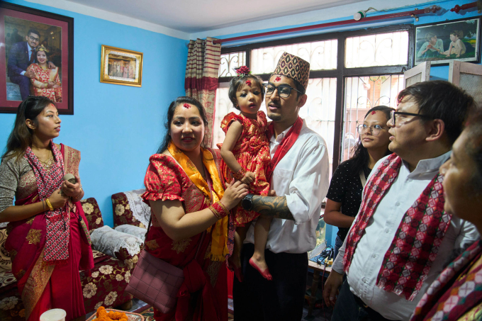 Bố mẹ của tân Thánh nữ bế con gái trong nhà riêng ở Kathmandu, trước giờ khởi hành tới đền Thánh nữ hôm 30/9. Ảnh: AP