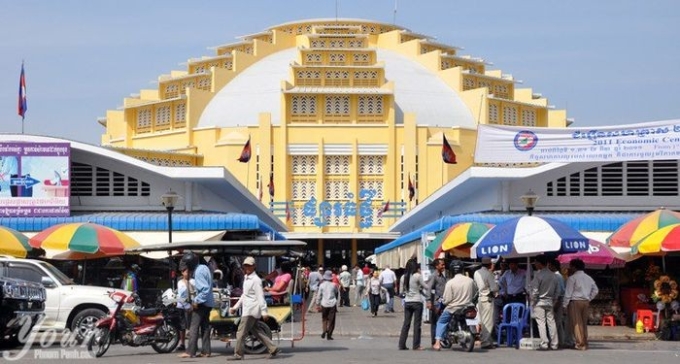 Cảnh sát đứng dưới những chiếc ô có chữ Lion bên ngoài chợ Phnom Penh. Ảnh: NVCC