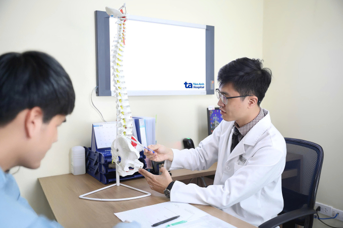Bác sĩ Thắng giải thích tình trạng sức khỏe cột sống cho người bệnh. Ảnh: Bệnh viện Đa khoa Tâm Anh