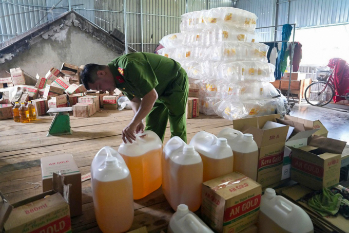 Cảnh sát kiểm tra các can nhựa đựng dầu ăn giả tại công ty của bà Mai. Ảnh: Công an cung cấp
