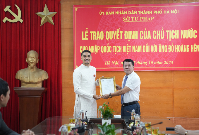 Phó Giám đốc Sở Tư pháp Hà Nội Phạm Thanh Cao (phải) trao quyết định của Chủ tịch nước cho nhập tịch Việt Nam với Đỗ Hoàng Hên (trái). Ảnh: Tam Anh