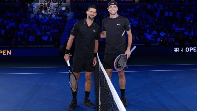 Djokovic (trái) và Fritz ở bán kết Mỹ Mở rộng, trên sân Arthur Ashe, New York hồi tháng trước. Ảnh: Reuters