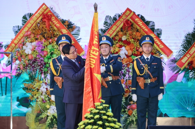 Thủ tướng Phạm Minh Chính gắn huy hiệu Danh hiệu Anh hùng lực lượng vũ trang nhân dân lên Quân kỳ Quyết thắng của Quân chủng Phòng không - Không quân. Ảnh: VGP/Nhật Bắc