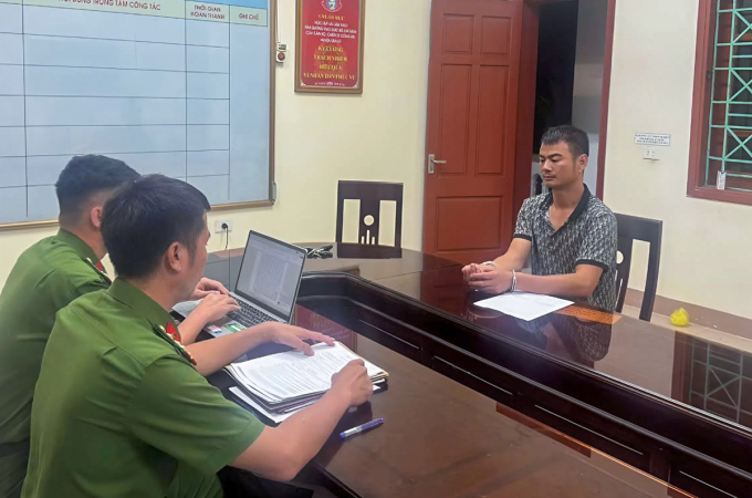 Hòa (góc phải), làm việc với cảnh sát. Ảnh:Công an cung cấp