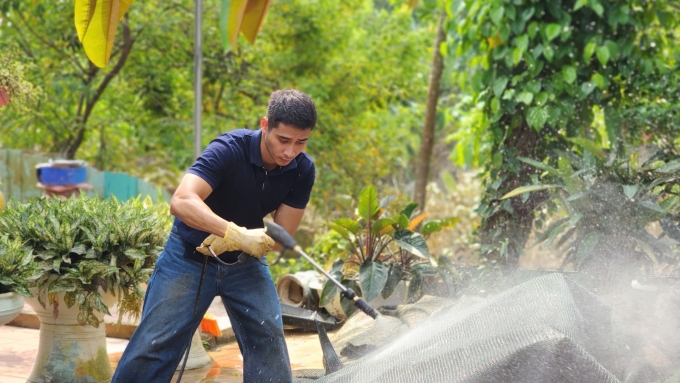 Nam vương Tuấn Ngọc xịt rửa các đồ dùng bám bùn đất.