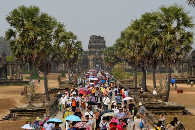 Du khách đi trên con đường dẫn đến Angkor Wat ở Siem Reap, Campuchia. Ảnh: AFP