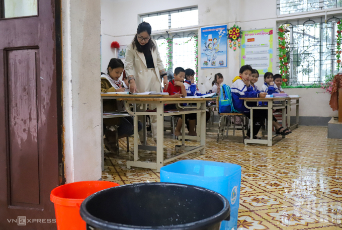 Trần tầng hai bị dột, cô giáo vừa dạy học vừa phải dùng xô hứng nước mưa để nước không tràn vào phòng, sáng 31/10. Ảnh: Đức Hùng