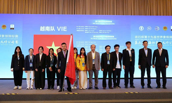Đội cờ tướng Việt Nam tại giải vô địch thế giới ở Thượng Hải, Trung Quốc, tháng 9/2025. HLV Trần Ngọc Long đứng ngoài cùng bên phải. Lại Lý Huynh cầm cờ trong lễ khai mạc. Ảnh: WXF