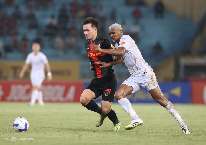 Nguyễn Hoàng Đức (trái) tranh chấp với Daniel Passira trong trận Ninh Bình thắng Hà Nội FC 2-1 ở vòng 7 V-League 2025-2026. Ảnh: Hoàng Huynh