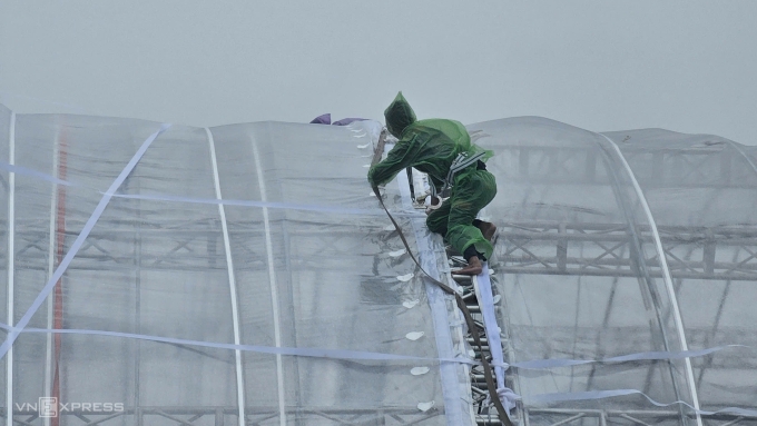 Đội kỹ thuật khắc phục mái rạp bị rách do mưa lớn.