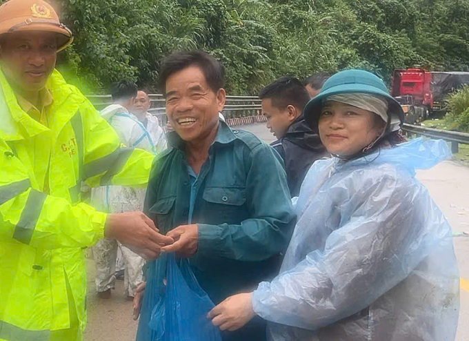 Một người mắc kẹt nhận đồ tiếp tế lương thực từ các đoàn hỗ trợ hôm 27/10. Ảnh: Công an tỉnh Quảng Ngãi