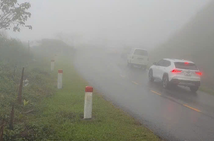 Ôtô bị hạn chế tầm nhìn do đèo Vi Ô Lắc mưa và sương mù. Ảnh: Mạnh Hào
