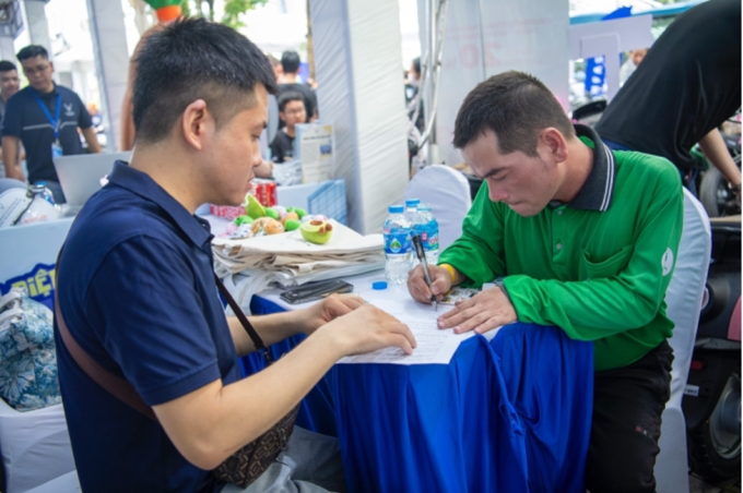 Một tài xế công nghệ đăng ký đổi xe xăng sang mẫu xe điện VinFast Evo200 ở một sự kiện. Ảnh: Tuấn Vũ