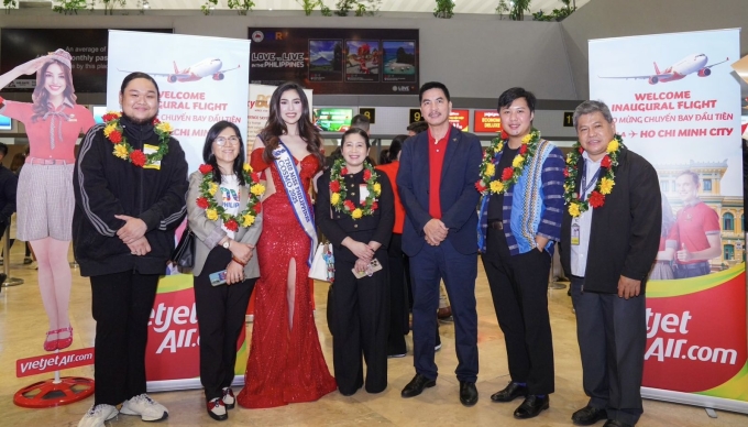 Giám đốc Thương mại Vietjet Hà Năng Việt (thứ ba từ phải sang) và Miss Cosmo Philippines 2025 Chelsea Fernandez chào đón các hành khách trên chuyến bay khai trương tại sân bay Ninoy Aquino. Ảnh: Tài Nguyễn