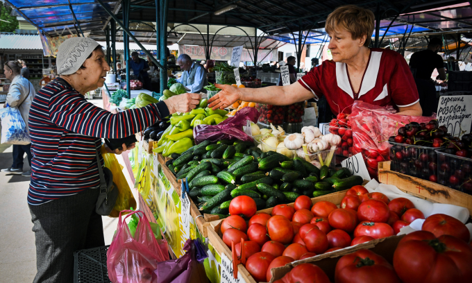 Giao dịch tại một quầy rau quả tại thủ đô Moskva của Nga hồi tháng 6. Ảnh: AFP