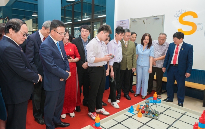 Các đại biểu tham quan và nghe giáo viên, học sinh giới thiệu về mô hình và hoạt động giảng dạy của phòng thực hành giáo dục STEM. Ảnh: PVCFC